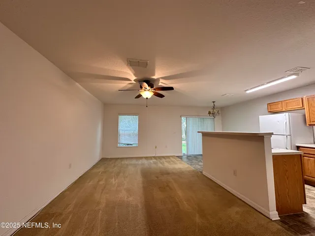 a view of a big room with wooden floor and windows
