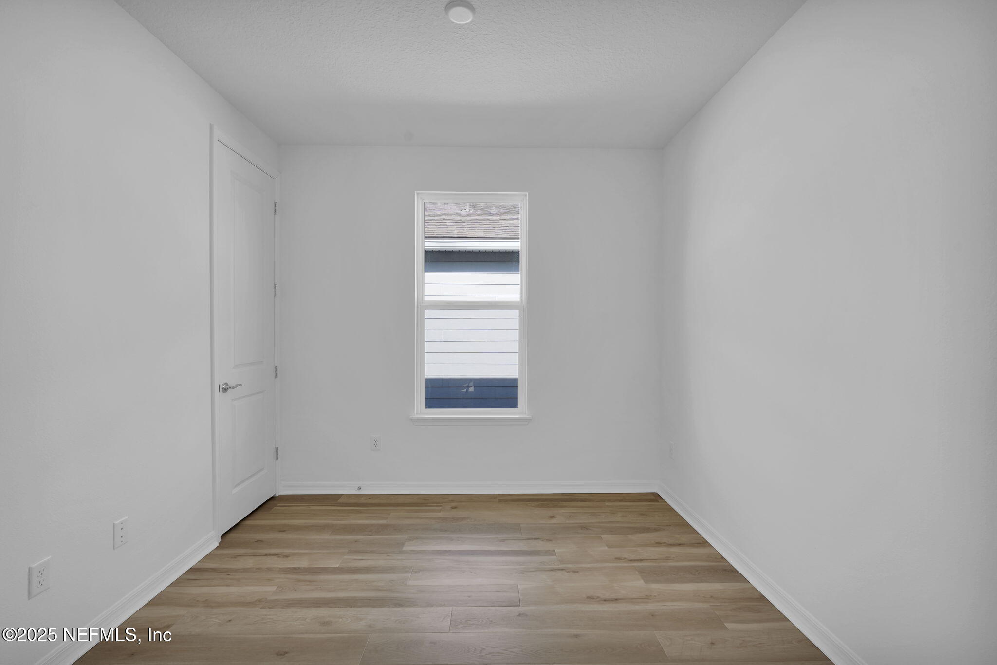 239 Fairlake Circle St. Augustine, FL 32092 - Photo 18 of 30 a view of an empty room with wooden floor and a window
