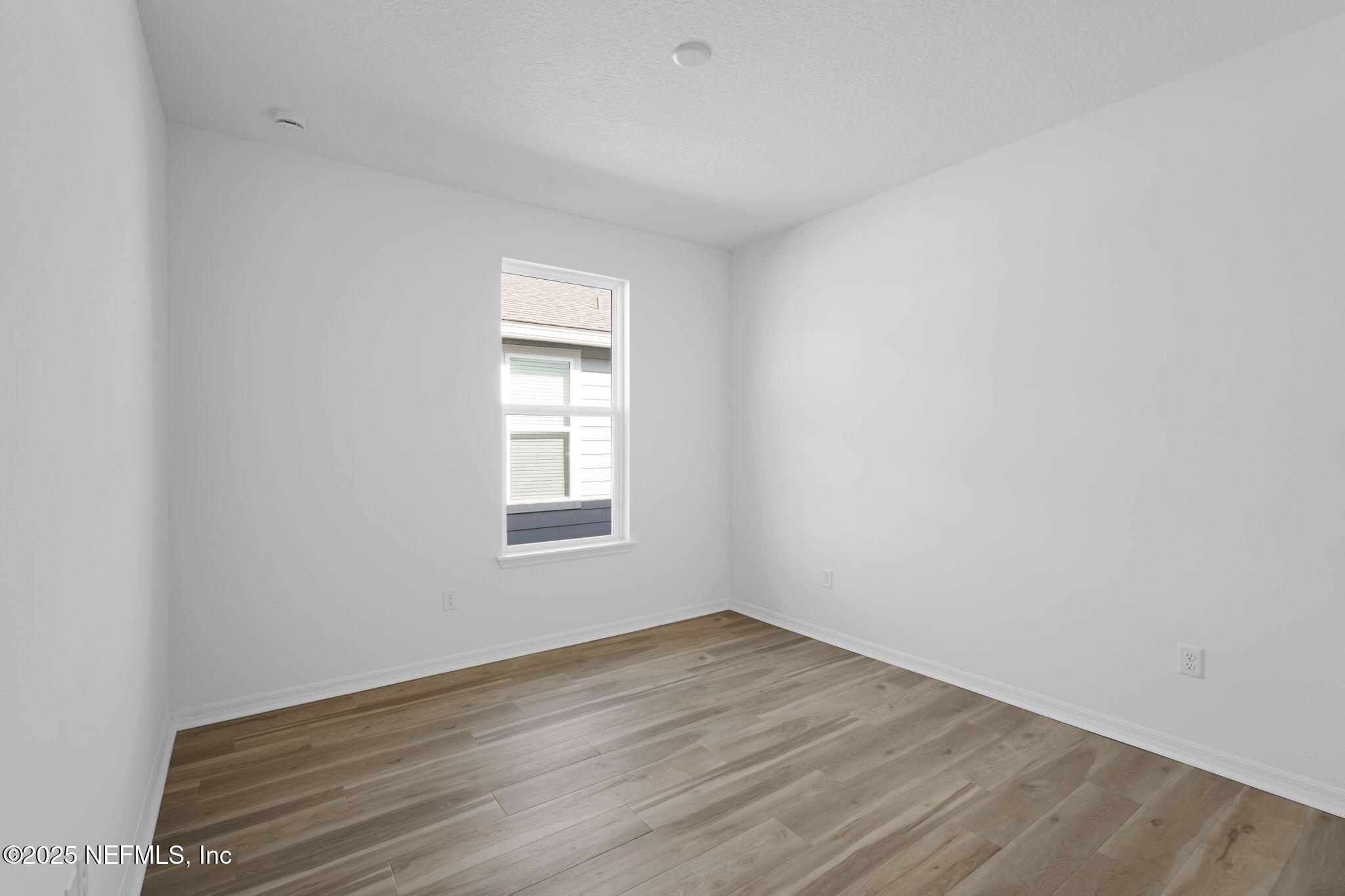 239 Fairlake Circle St. Augustine, FL 32092 - Photo 19 of 30 an empty room with wooden floor and windows