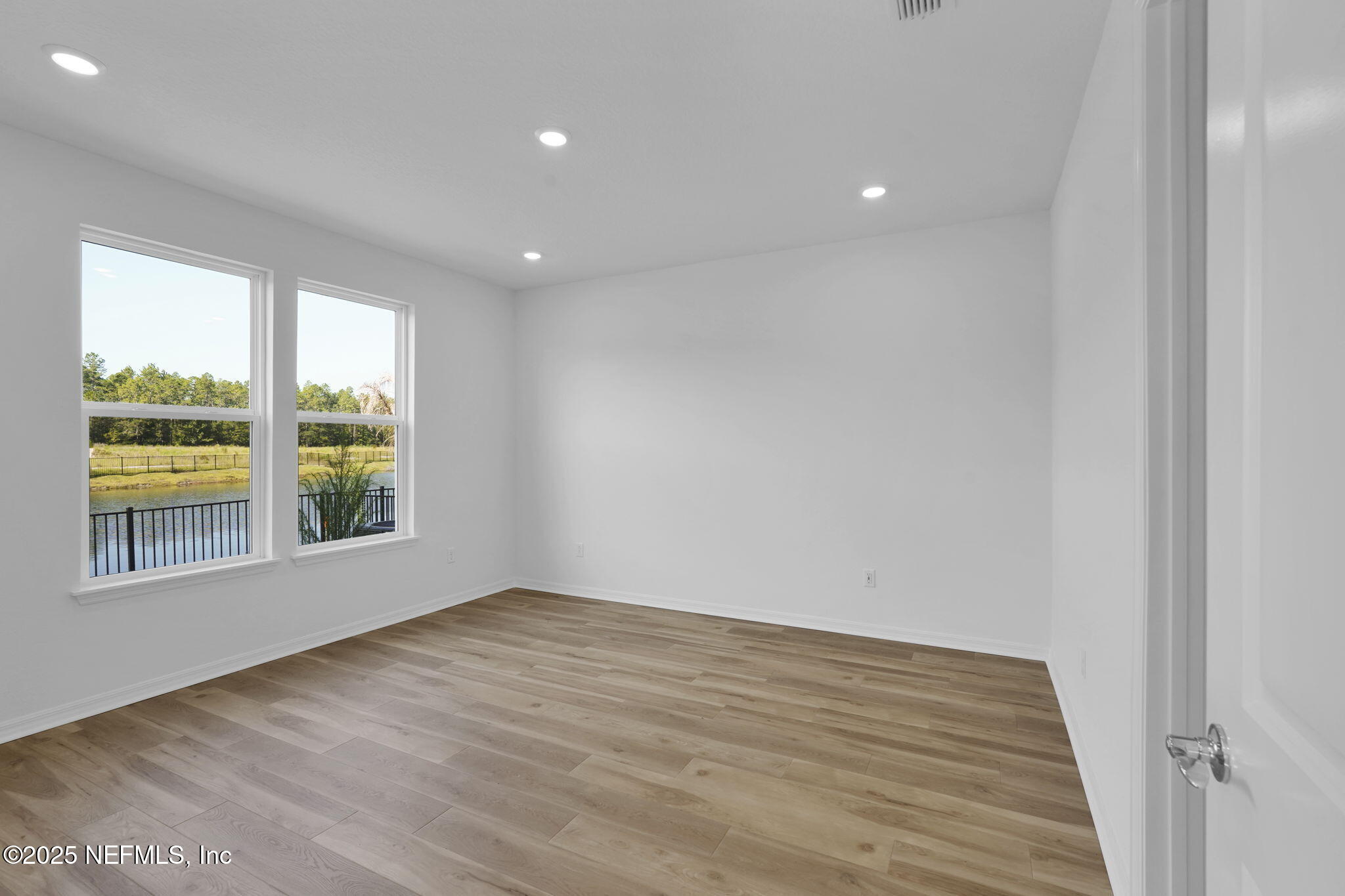 239 Fairlake Circle St. Augustine, FL 32092 - Photo 21 of 30 a view of an empty room with wooden floor and a window