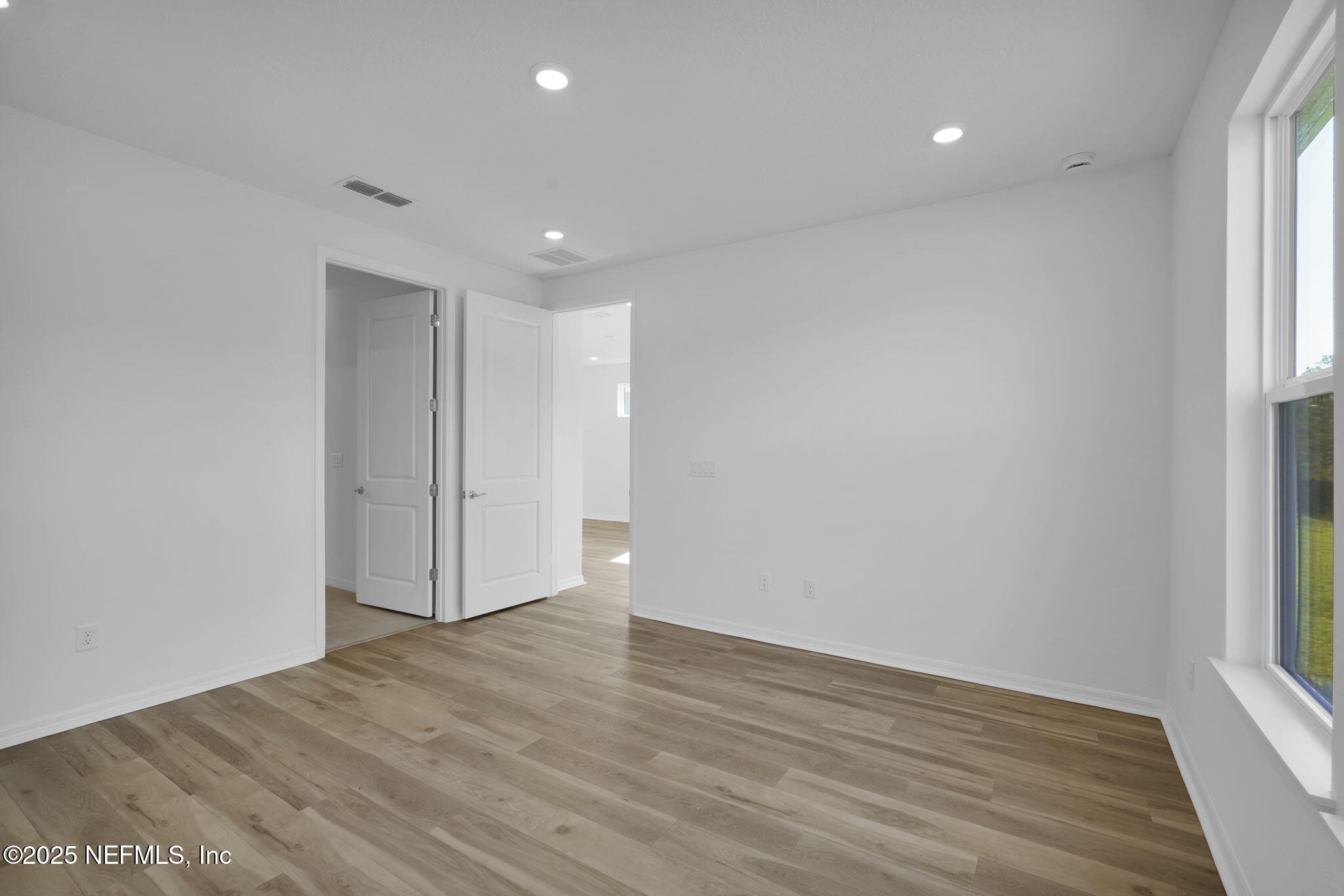 239 Fairlake Circle St. Augustine, FL 32092 - Photo 23 of 30 a view of an empty room with wooden floor and a window