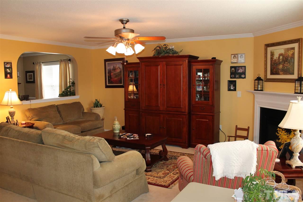 3108 Varcroft Road Knightdale, NC 27545 - Photo 3 of 17 a living room with furniture a fireplace and a chandelier