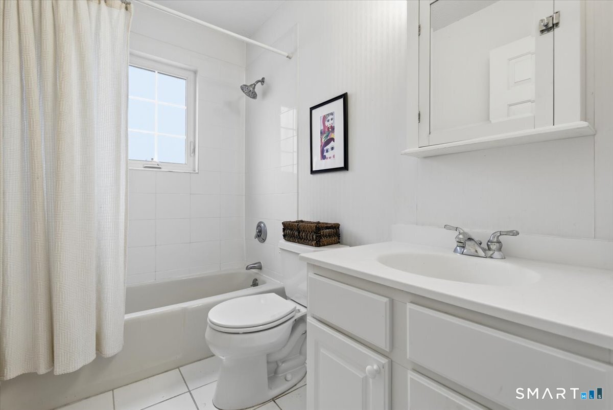 367 Main Street, Unit 7 Old Saybrook, CT 06475 - Photo 24 of 27 a bathroom with a granite countertop toilet sink and mirror