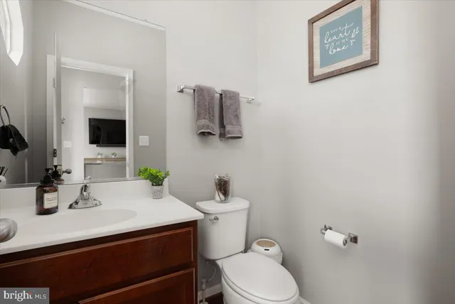 a bathroom with a granite countertop sink mirror and toilet