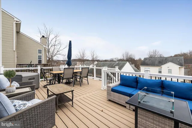 a roof deck with couches and wooden floor