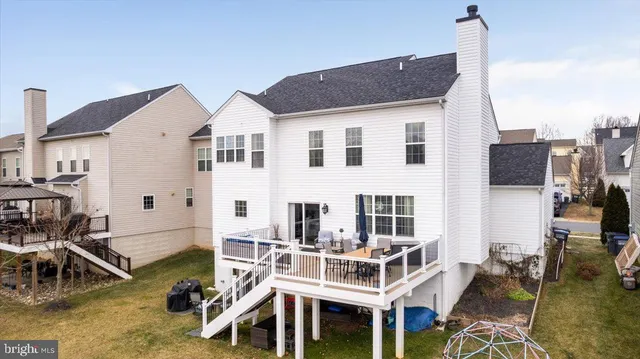 a view of a house with wooden deck and furniture