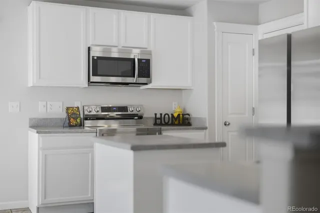 a kitchen with stainless steel appliances granite countertop white cabinets and a stove