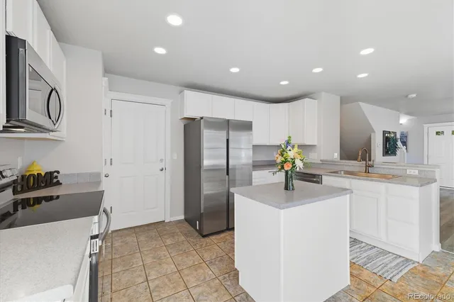 a kitchen with stainless steel appliances a sink stove and refrigerator