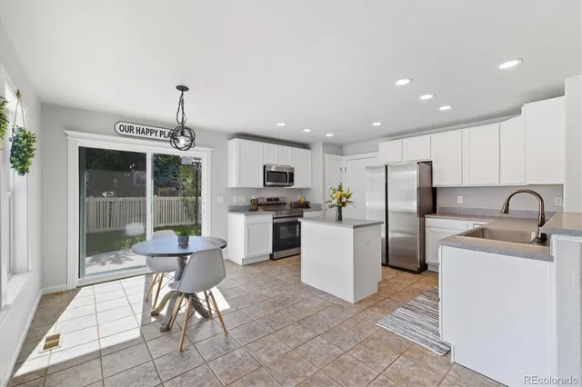 a kitchen with a refrigerator a sink and a stove top oven