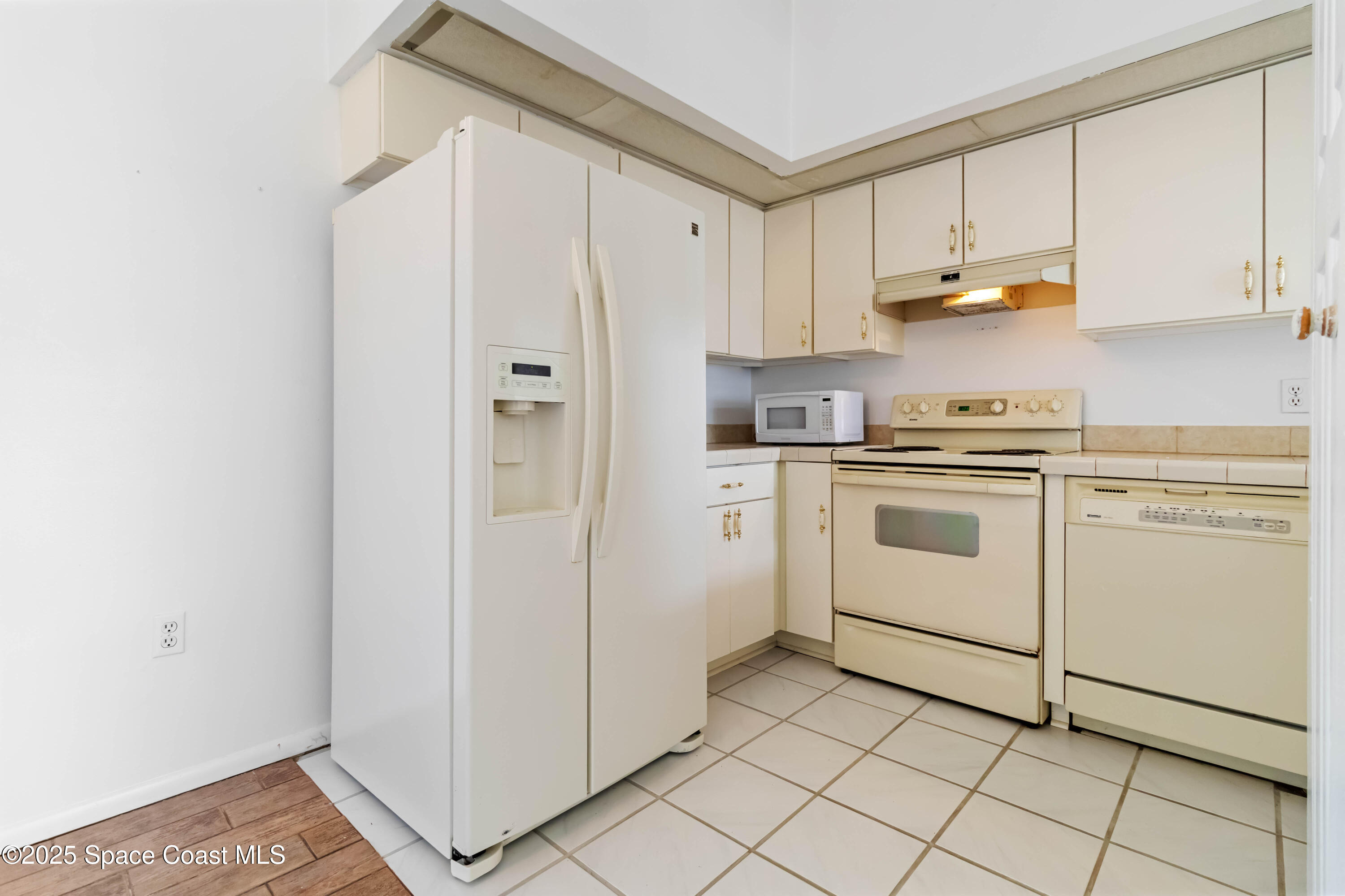 3728 West Malory Court Cocoa, FL 32926 - Photo 20 of 37 a kitchen with cabinets and white appliances