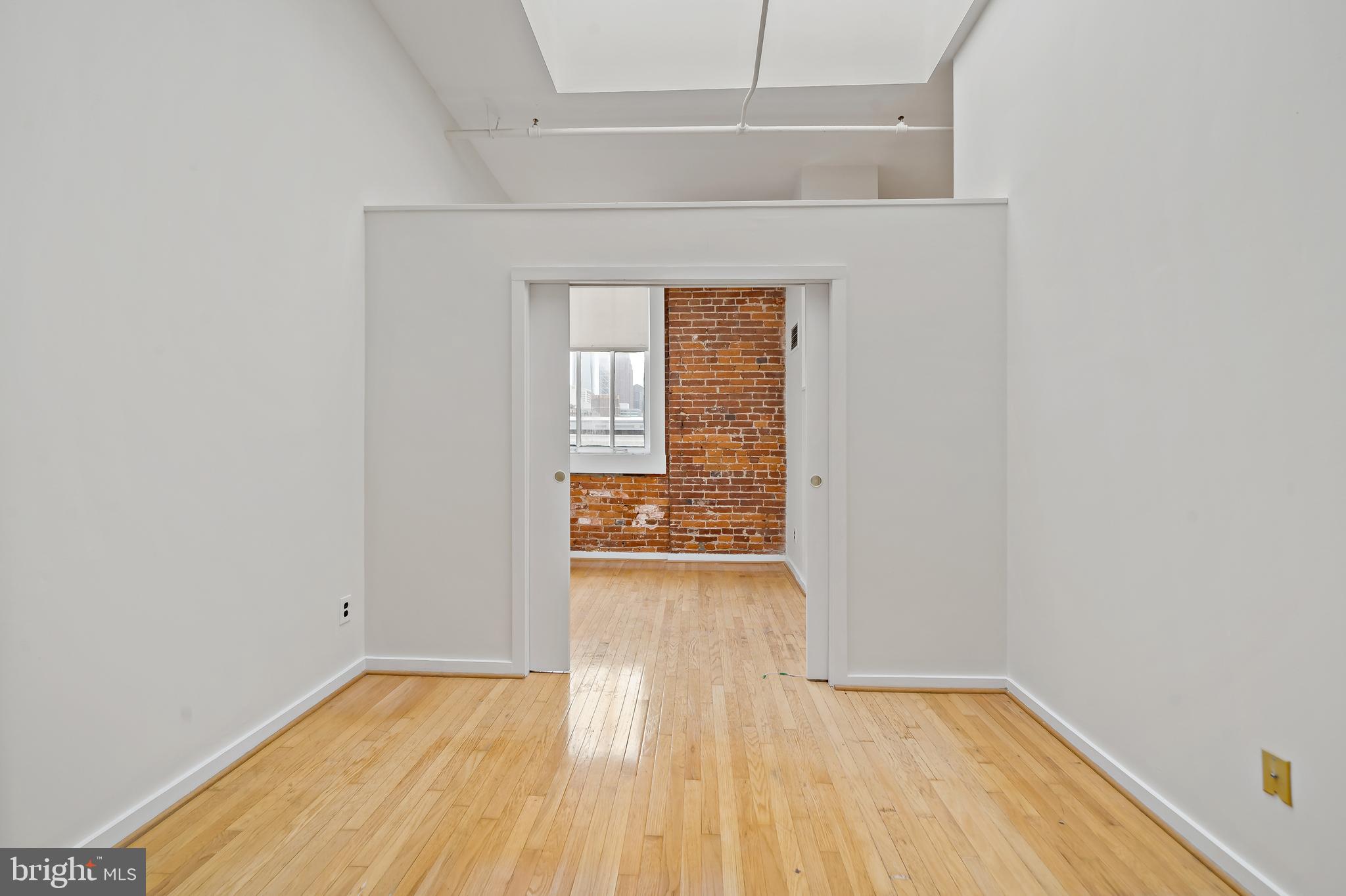 1010 Race Street, Unit PG Philadelphia, PA 19107 - Photo 8 of 14 a view of an empty room with wooden floor and a window