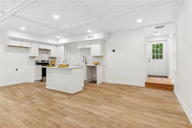 a kitchen with a sink a stove and wooden floors