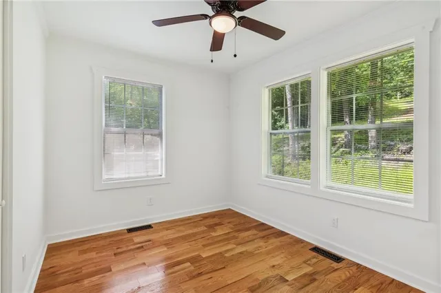 a view of empty room with wooden floor