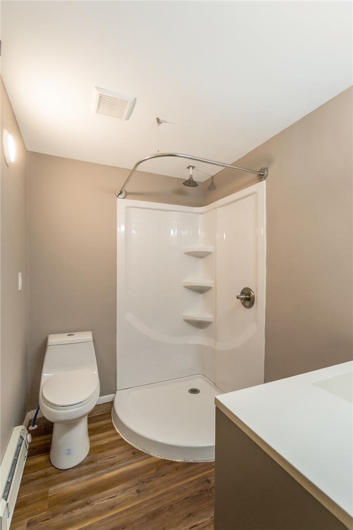 121 Short Ridge Road Albrightsville, PA 18210 - Photo 16 of 35 Rich wood-look flooring grounds this functional bathroom featuring a modern corner shower setup.