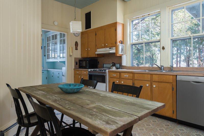 101 Associates Road Falmouth, MA 02540 - Photo 12 of 31 a kitchen with a table chairs sink and cabinets