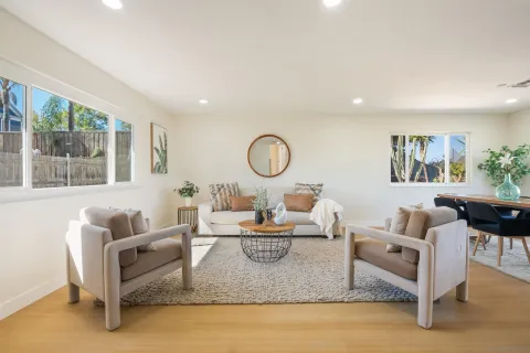a living room with furniture a large window and a table