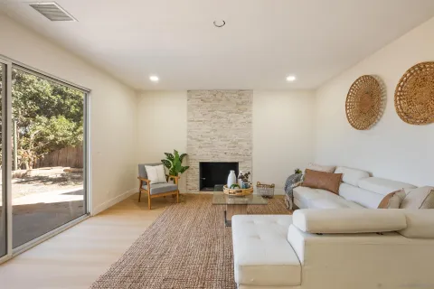 a living room with furniture a large window and a fireplace