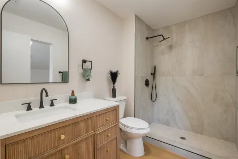 a bathroom with a sink a toilet and shower