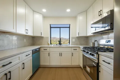 a kitchen with stainless steel appliances granite countertop a sink stove and cabinets