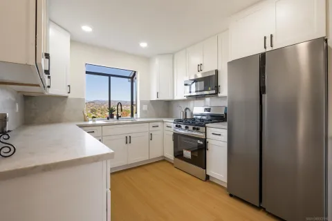 a kitchen with stainless steel appliances granite countertop a refrigerator sink and stove