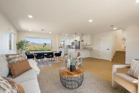 a living room with furniture and a view of kitchen
