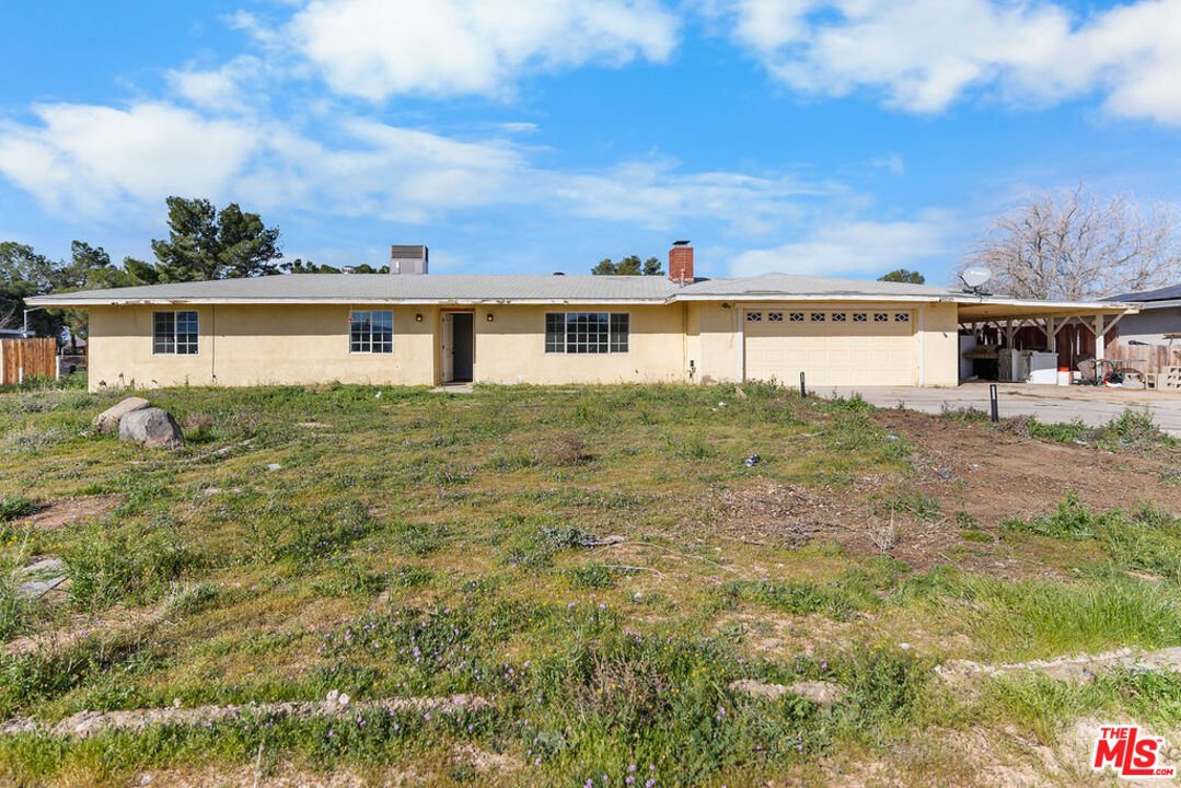 a view of house with yard and trees in the background