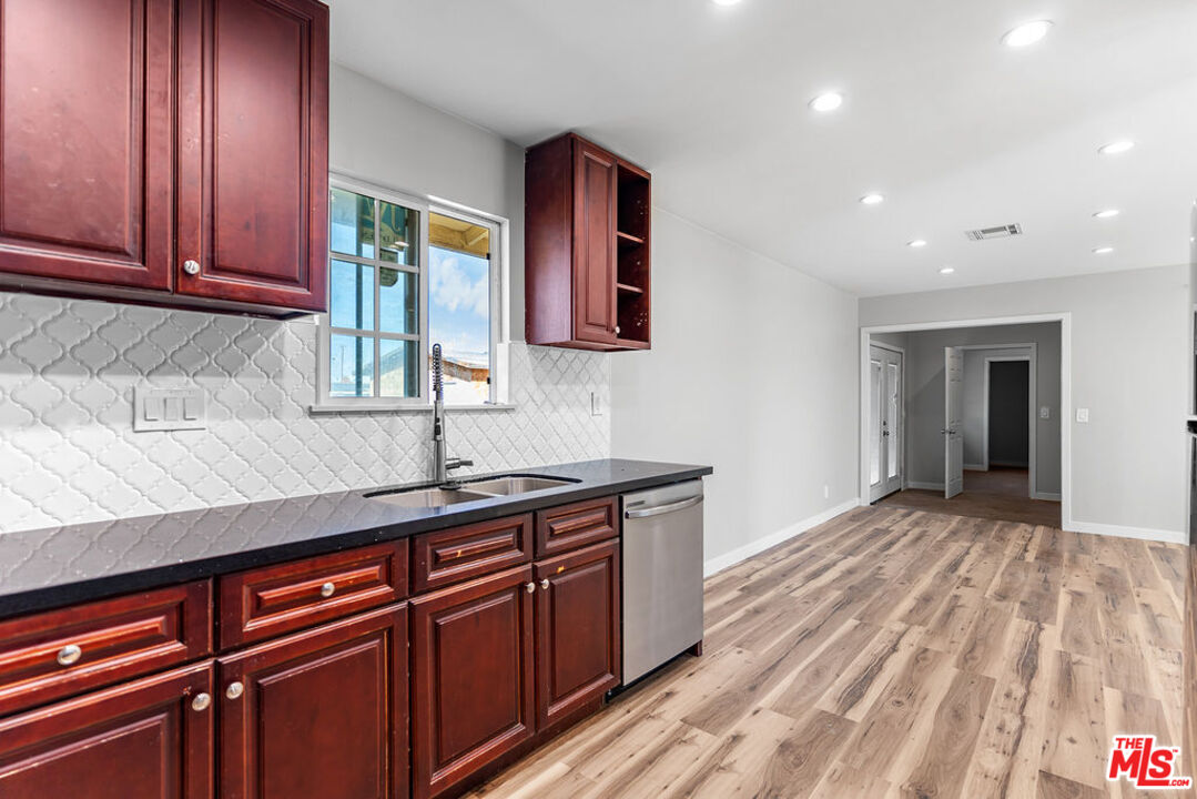 16030 Osage Road Apple Valley, CA 92307 - Photo 11 of 27 a kitchen with stainless steel appliances granite countertop wooden cabinets a sink and dishwasher