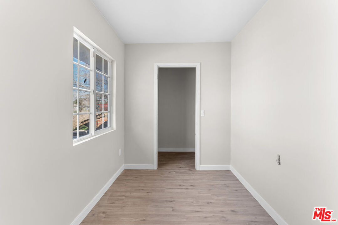 16030 Osage Road Apple Valley, CA 92307 - Photo 13 of 27 a view of an empty room with wooden floor and a window