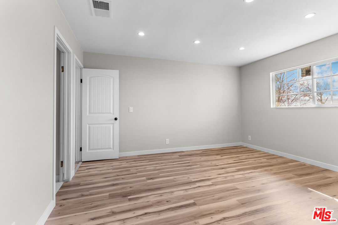 16030 Osage Road Apple Valley, CA 92307 - Photo 22 of 27 an empty room with wooden floor and window