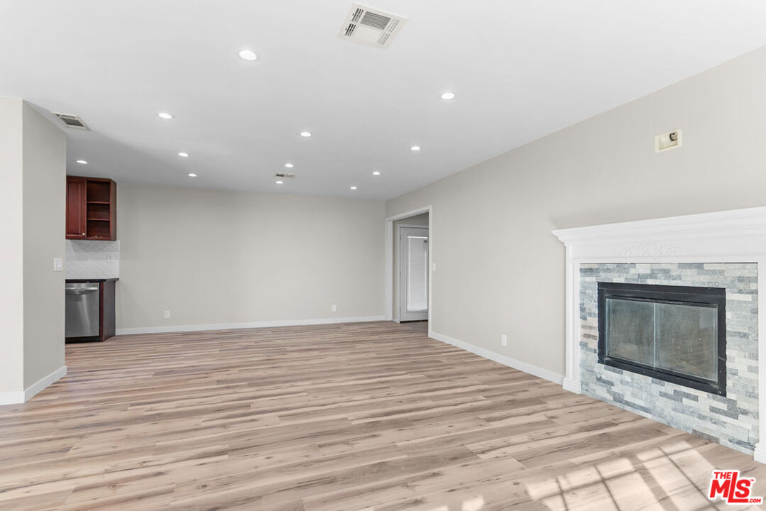 16030 Osage Road Apple Valley, CA 92307 - Photo 6 of 27 a view of an empty room with wooden floor fireplace and a window