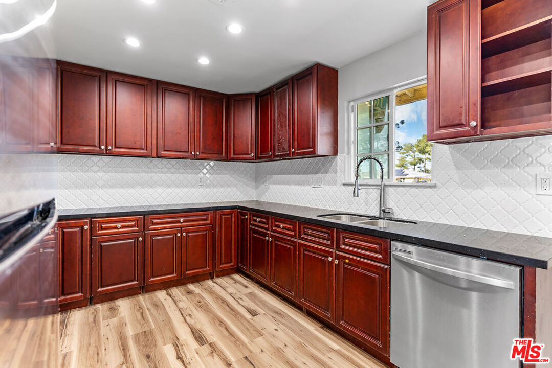16030 Osage Road Apple Valley, CA 92307 - Photo 9 of 27 a kitchen with stainless steel appliances granite countertop wooden cabinets a sink and dishwasher
