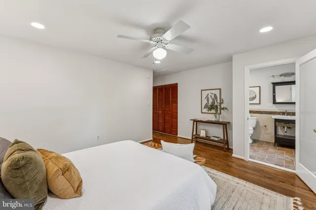 an empty room with wooden floor chandelier fan and windows