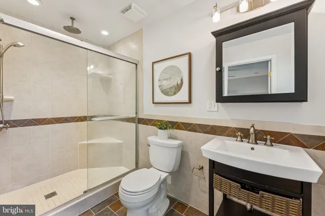 a bathroom with a toilet a sink and mirror
