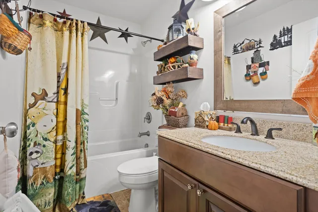 a bathroom with a granite countertop sink toilet and shower