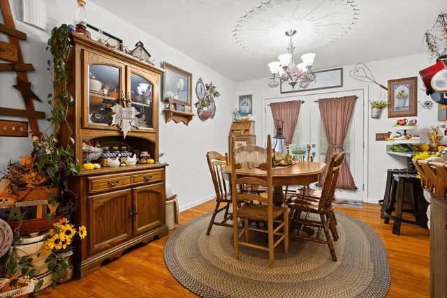 a view of a dining room with furniture a chandelier and wooden floor