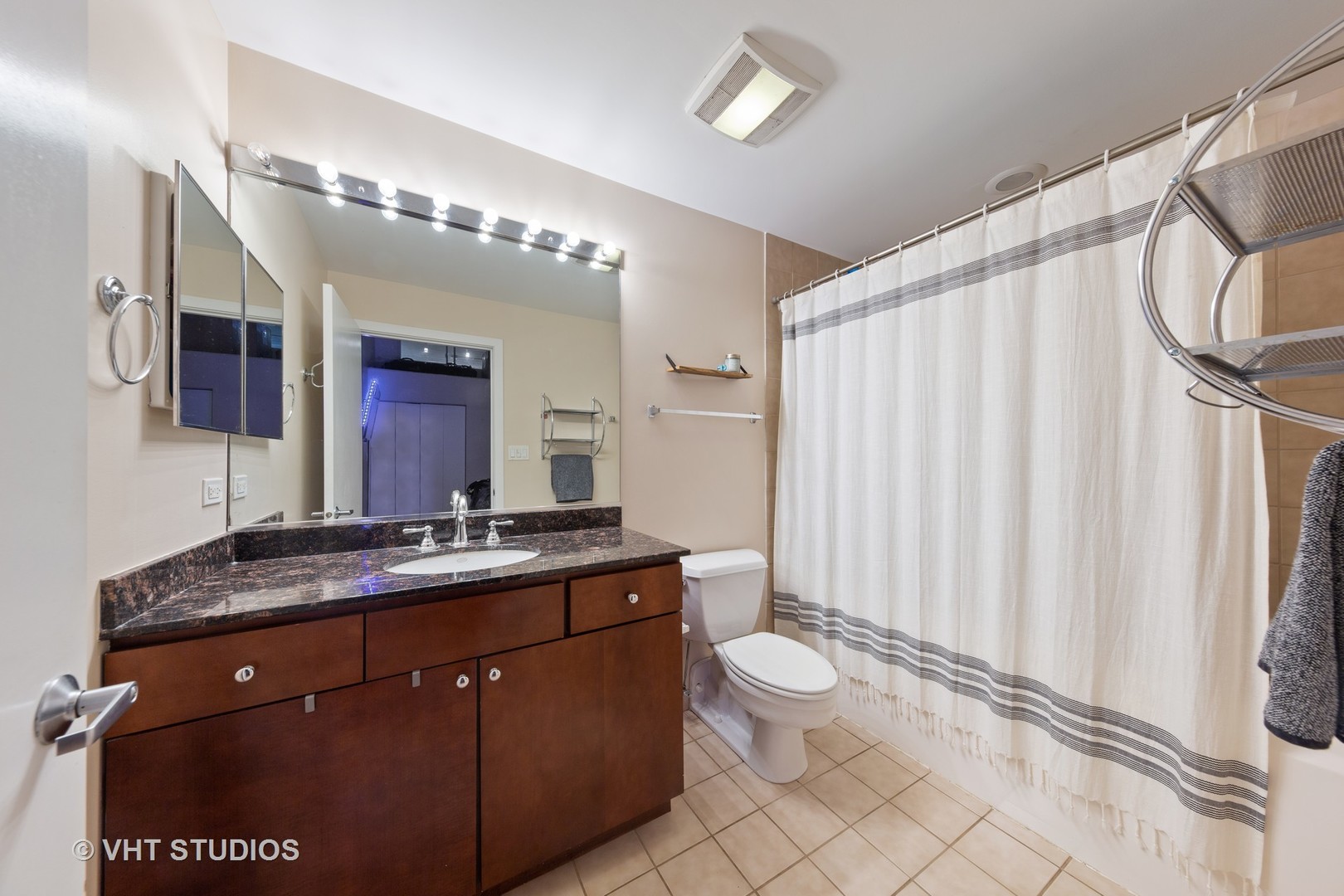 1111 West 15th Street, Unit 115 Chicago, IL 60608 - Photo 16 of 22 a spacious bathroom with a granite countertop sink toilet and mirror