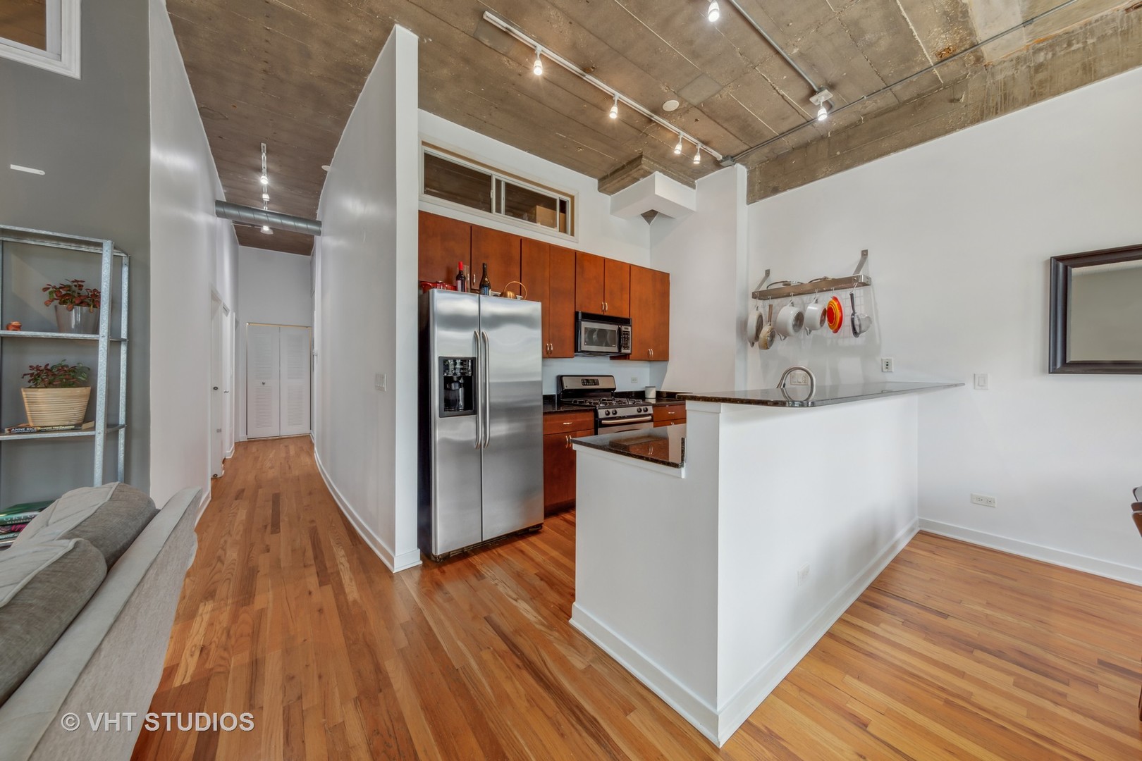 1111 West 15th Street, Unit 115 Chicago, IL 60608 - Photo 9 of 22 a kitchen with stainless steel appliances granite countertop a refrigerator and a wooden floor