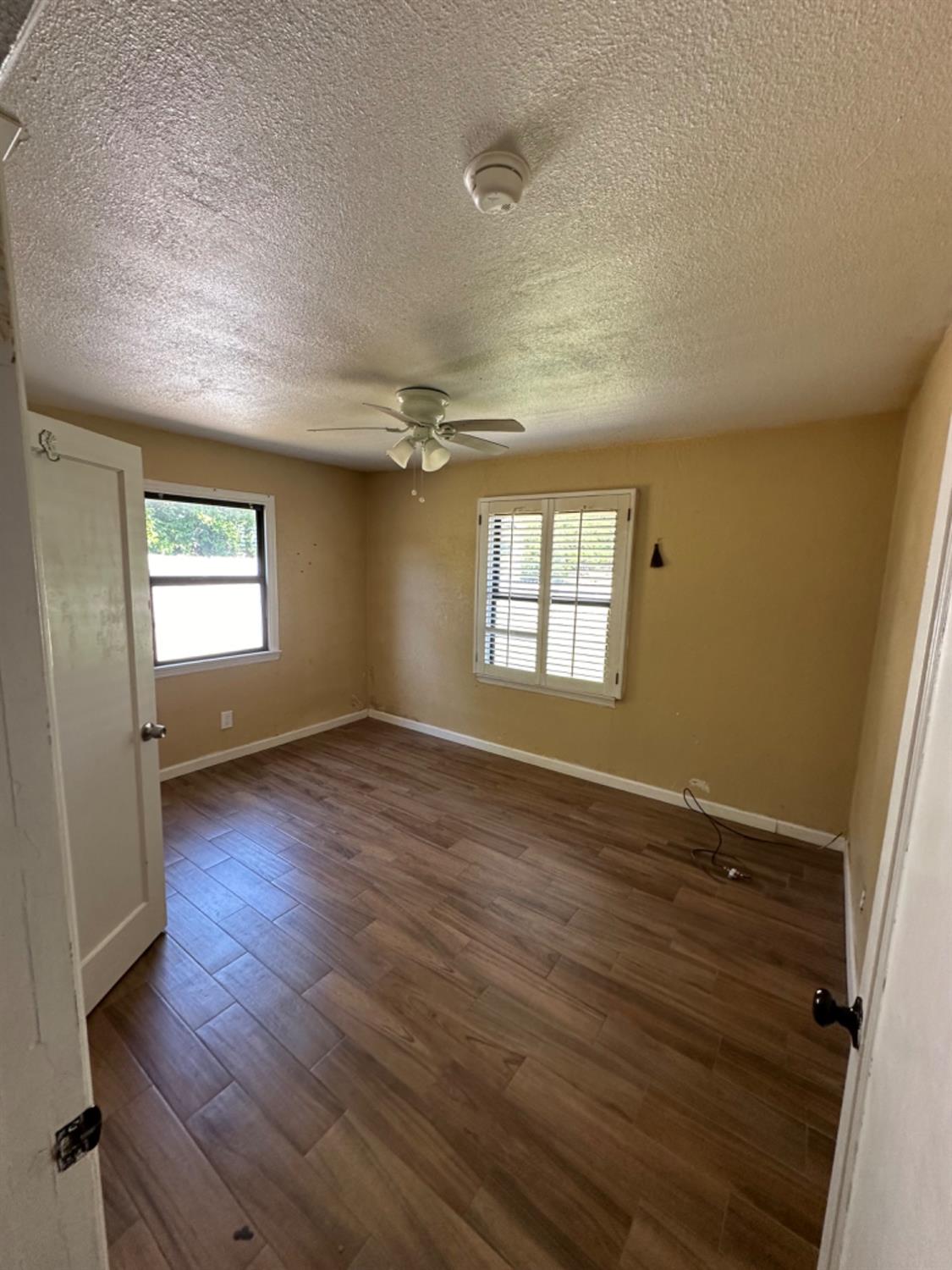 1474 Smith Road Yuba City, CA 95993 - Photo 6 of 12 an empty room with wooden floor and windows