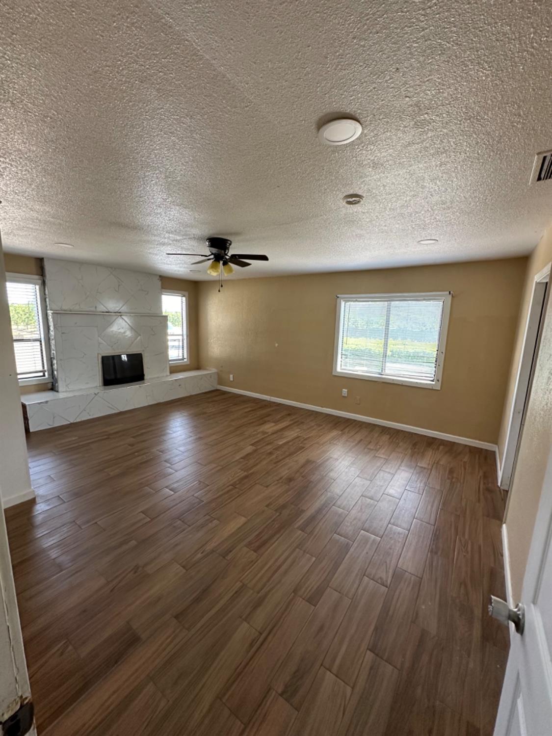 1474 Smith Road Yuba City, CA 95993 - Photo 7 of 12 an empty room with wooden floor and windows
