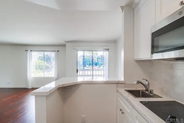 a kitchen with a sink a microwave and cabinets