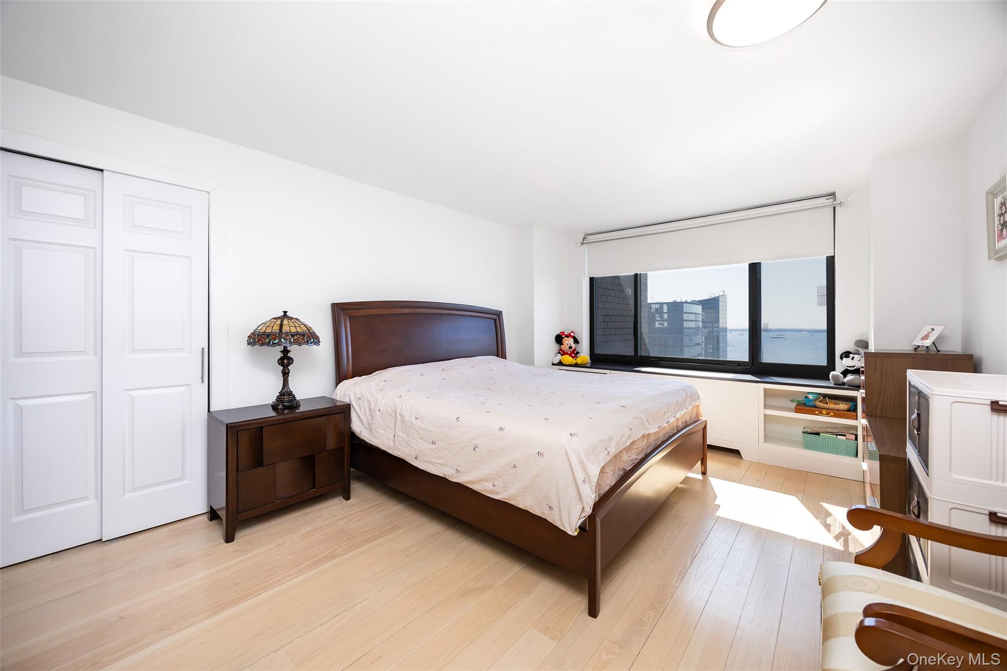 200 Rector Place, Unit 43D Manhattan, NY 10280 - Photo 11 of 27 a bedroom with a bed and large mirror