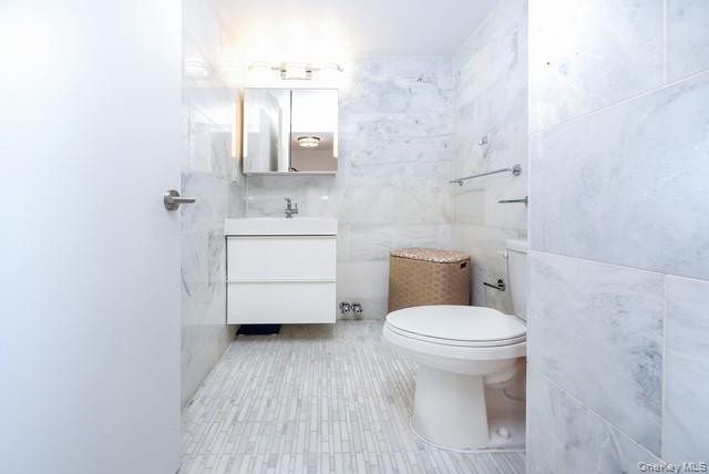 200 Rector Place, Unit 43D Manhattan, NY 10280 - Photo 4 of 27 a bathroom with a sink a toilet and a mirror