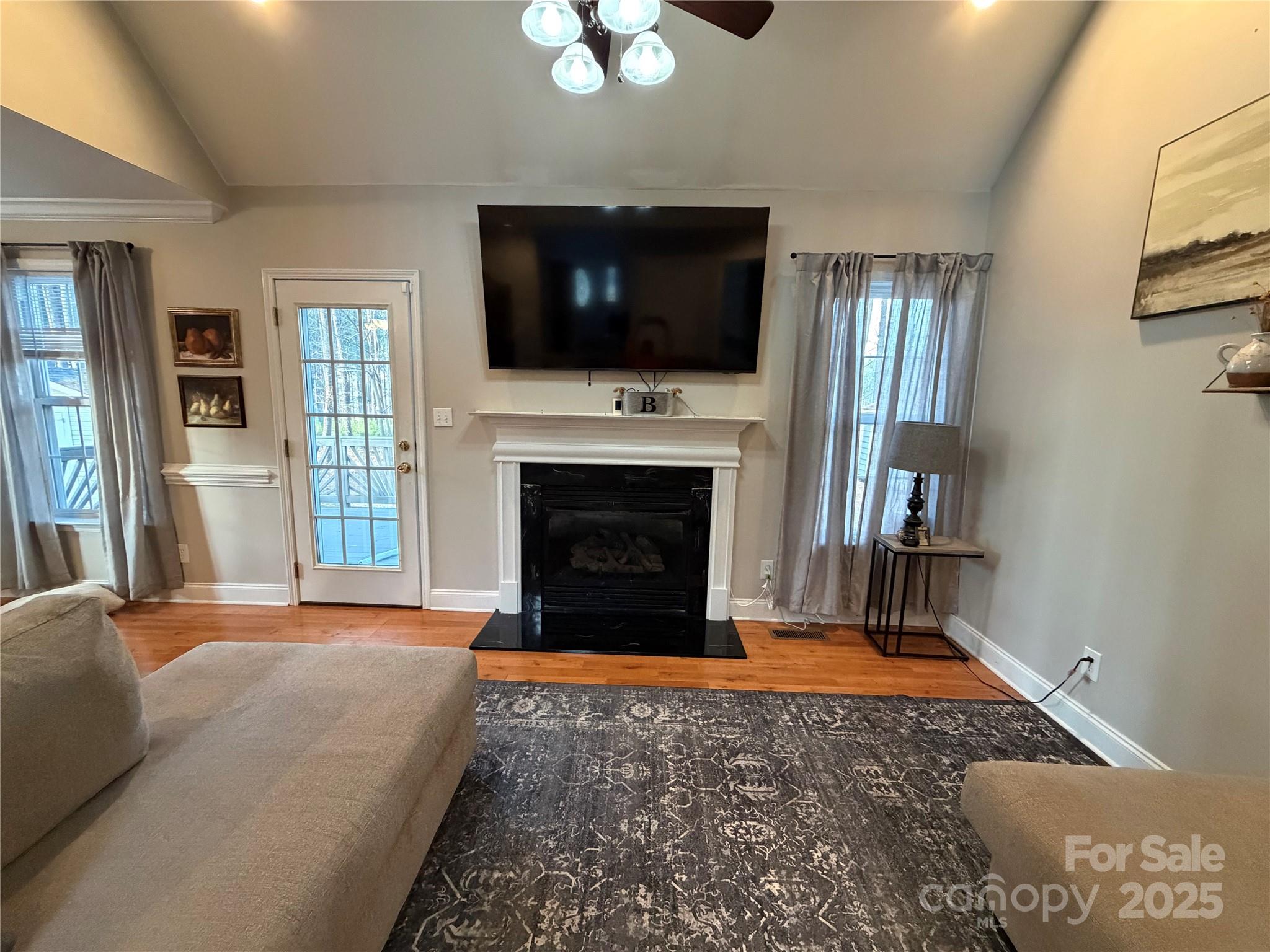 316 Durham Road Stanley, NC 28164 - Photo 9 of 16 a living room with a fireplace and a flat screen tv