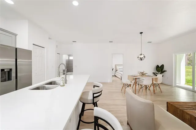 a dining room with furniture a chandelier and wooden floor