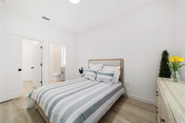 a bedroom with a bed and a potted plant