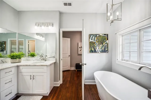 an empty room with wooden floor and a ceiling fan