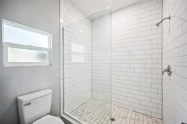 a bathroom with a granite countertop sink a toilet and mirror