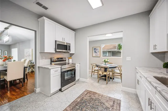 a kitchen with stainless steel appliances granite countertop a stove a sink and a refrigerator