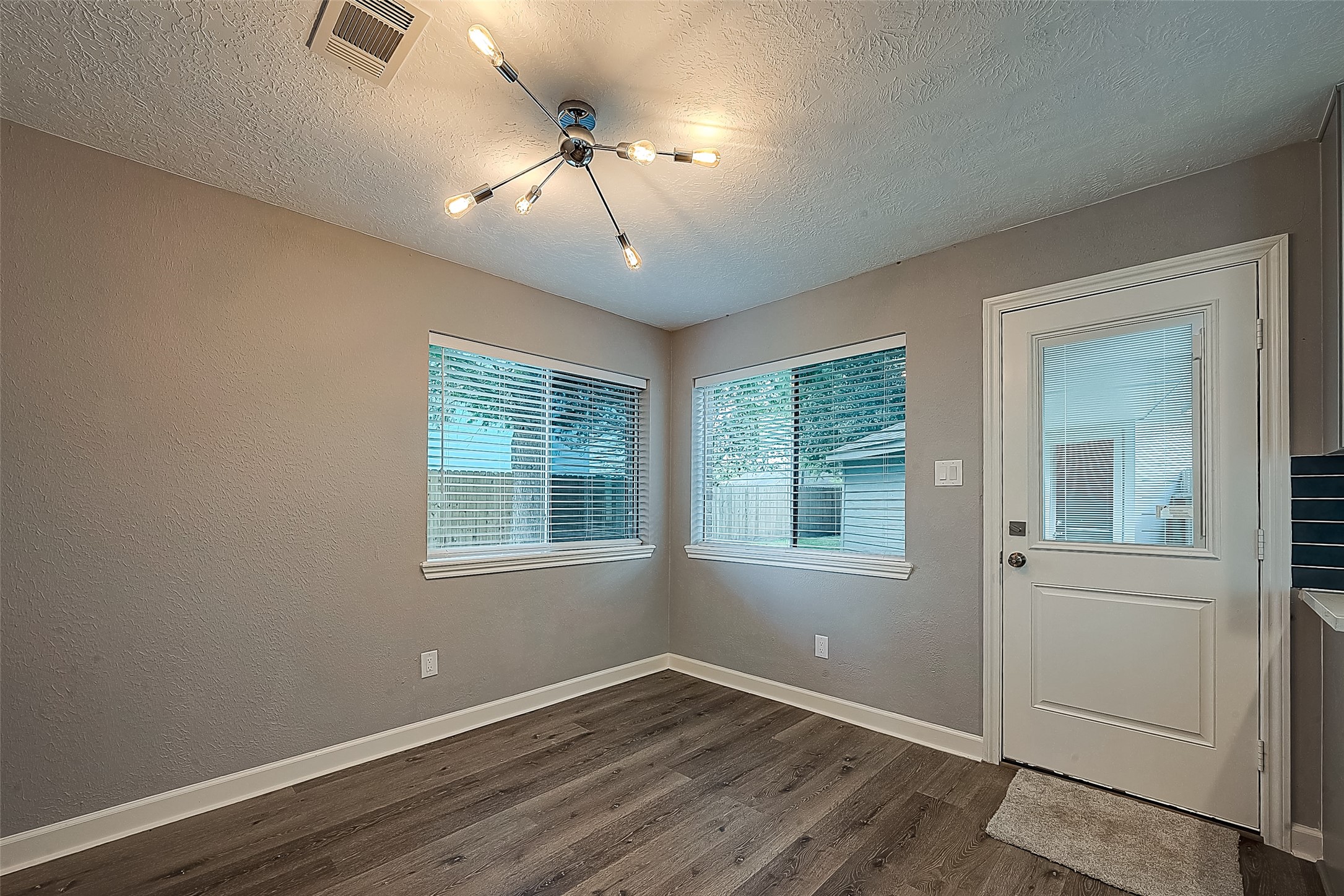 1623 Cherry Ridge Drive Houston, TX 77077 - Photo 9 of 44 an empty room with wooden floor chandelier and windows