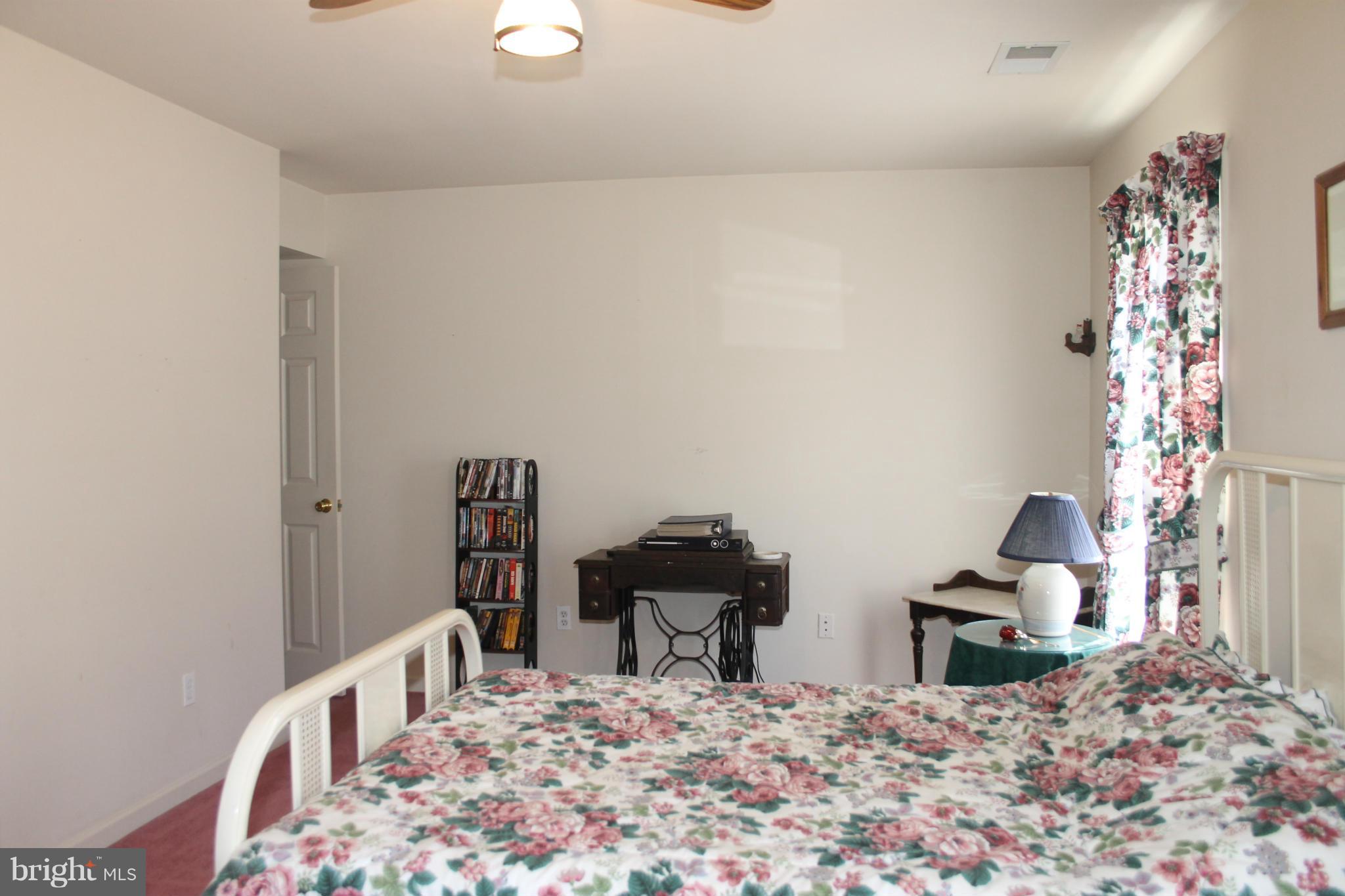10275 Dutch Hollow Road Rixeyville, VA 22737 - Photo 11 of 21 a view of a bedroom with bed and workspace